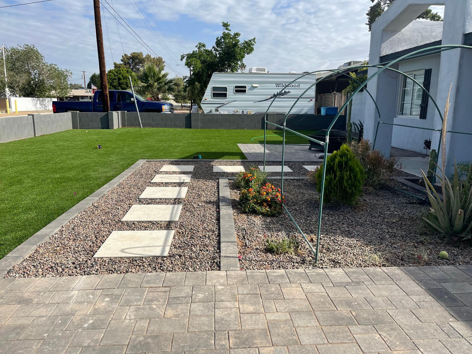 Paver walkway with stepping stones, decorative granite, and turf lawn
